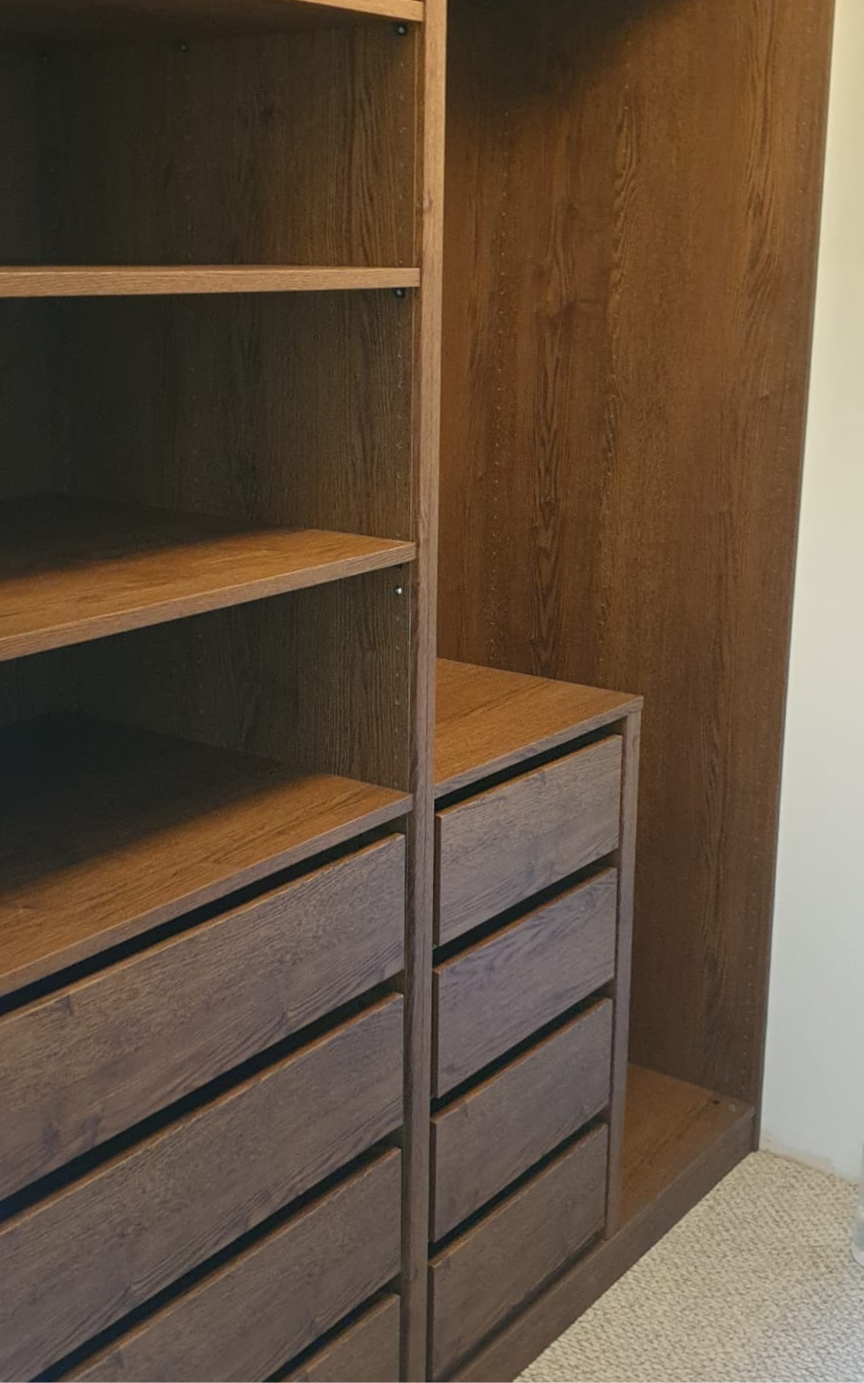 Inside a dark timber build in wardrobe with drawers